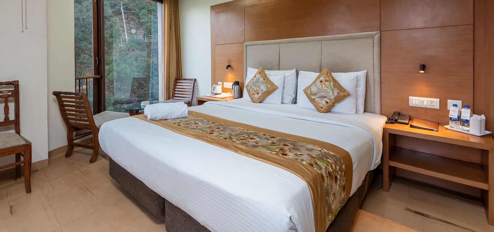 Executive Room 3D with front-facing jungle view featuring a king size bed and a table with tea & coffee make next to the bed at DLS Hotels The Rock Castle.